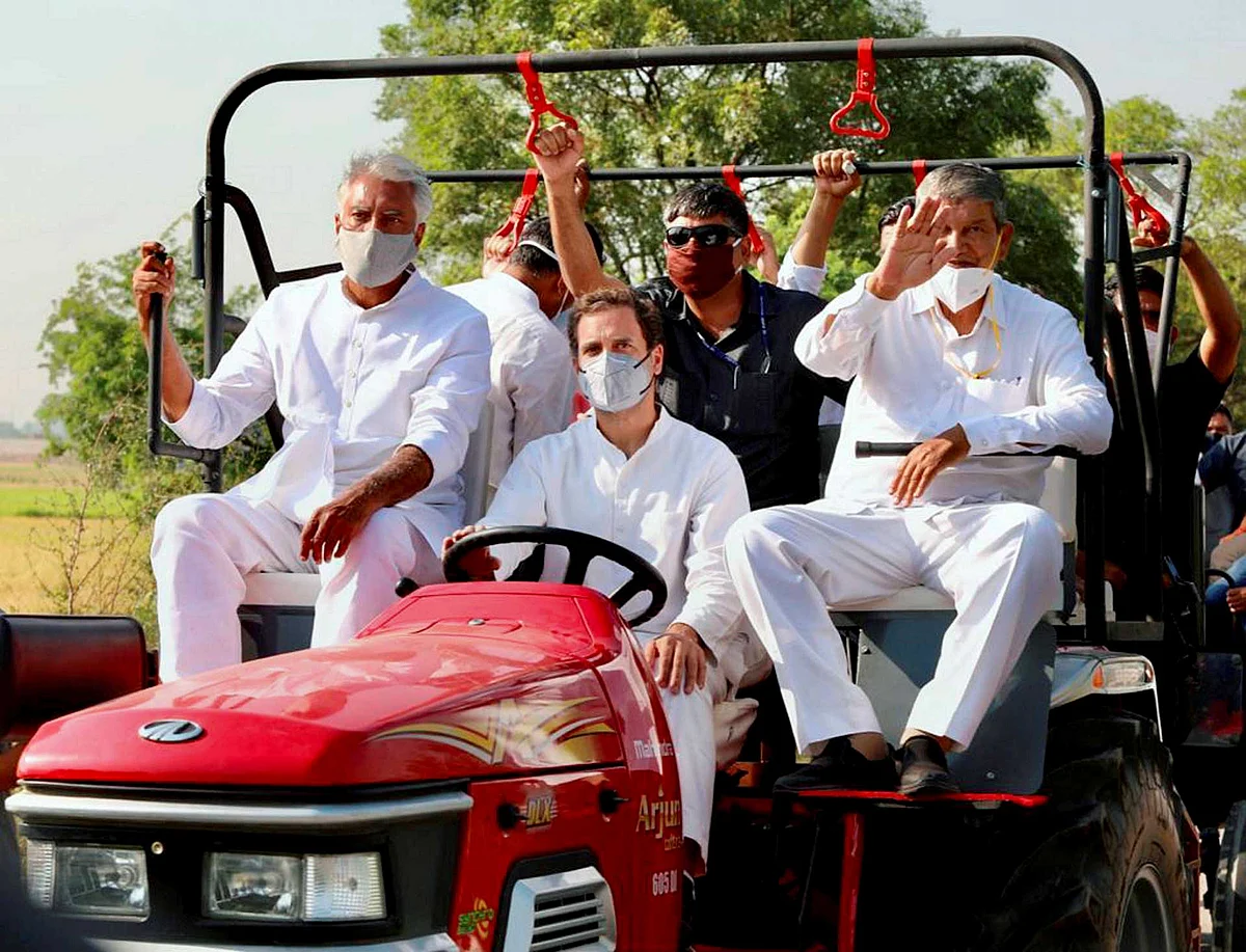 Congress leader Rahul Gandhi drives a tractor during the party’s Kheti Bachao tractor rally against the farm laws, at Haryan-Punjab border