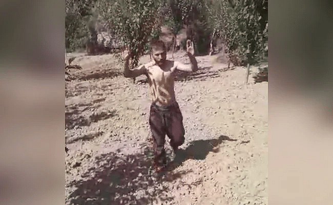 In the video, a man who recently went missing from home, is seen surrendering before the army along with an AK 47