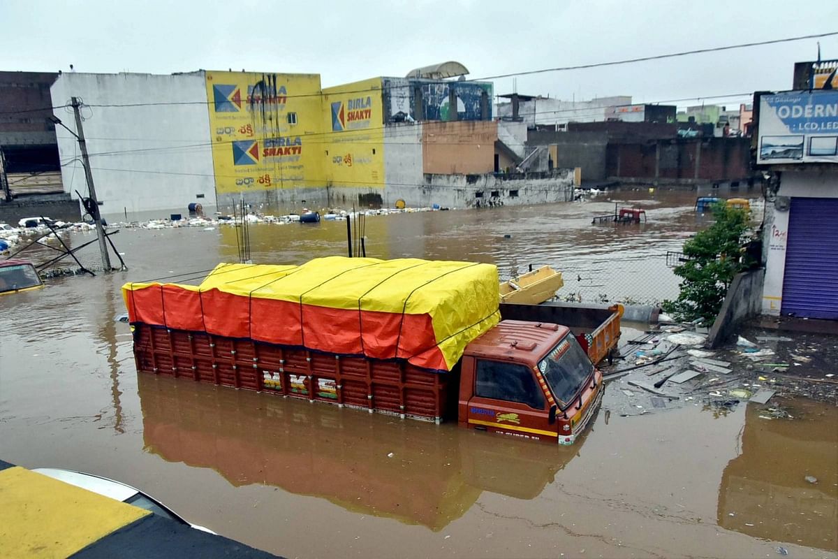 Vehicles lie partially submerged in floodwater following heavy rains, at Falaknuma, in Hyderabad, Wednesday, Oct. 14, 2020