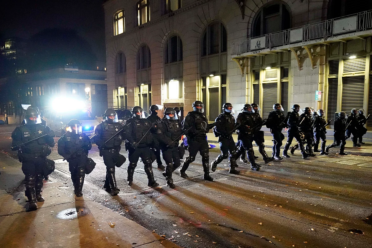 Police officers follow protesters in Portland, Ore., Wednesday, Nov. 4, 2020, following Tuesdays election