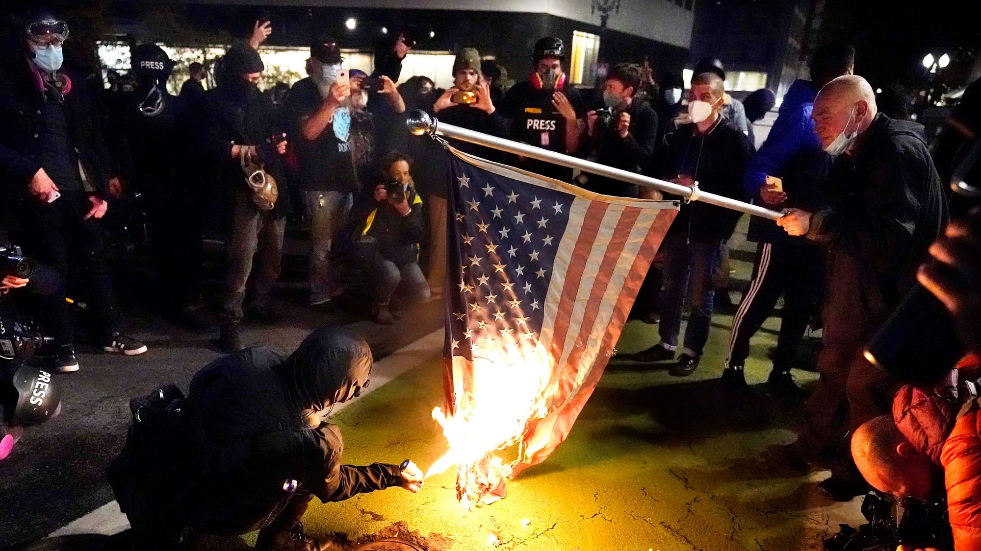 A protester lights an American flag on fire during a demonstration Wednesday, Nov. 4, 2020, in Portland.