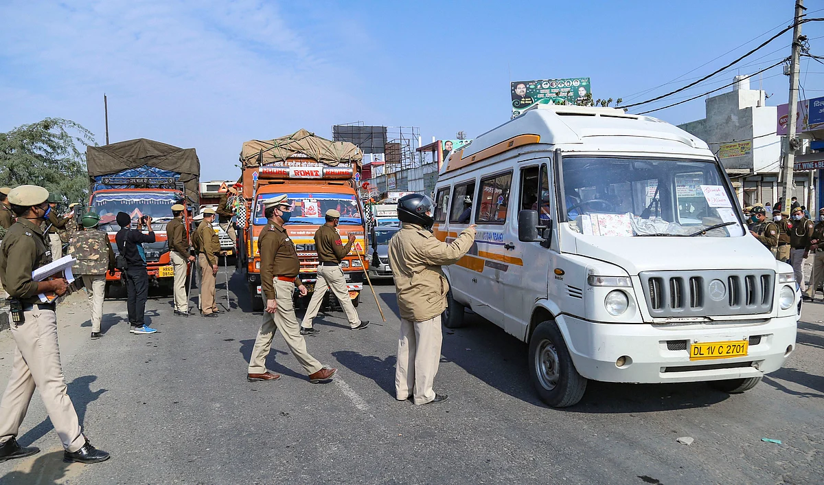 Police personnel check vehicles as the security is enhanced at Singhu border in view of the Delhi Chalo protest march by farmers against the new farm laws, in New Delhi