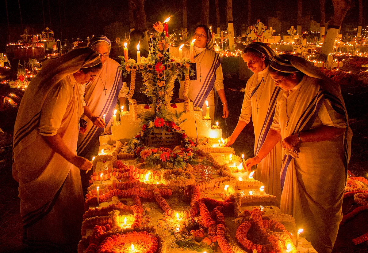 Christians light candles at graves of their relatives at a cemetery on All Souls Day, in Nadia.