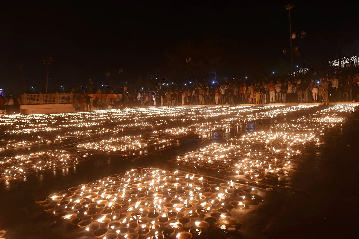Devotees light earthen lamps on the bank of Saryu River during Deepotsav celebrations in Ayodhya, Friday, 13 November.