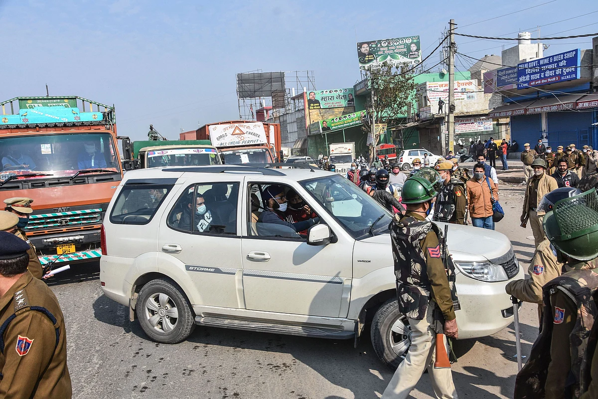 Police personnel check vehicles as the security is enhanced at Singhu border in view of the Delhi Chalo protest march by farmers against the new farm laws, in New Delhi