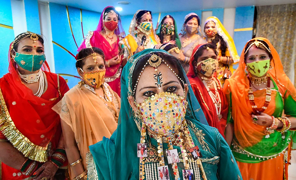 Women wearing designer masks pose for photographs as they prepare to celebrate Karwa Chauth festival in Bhopal.