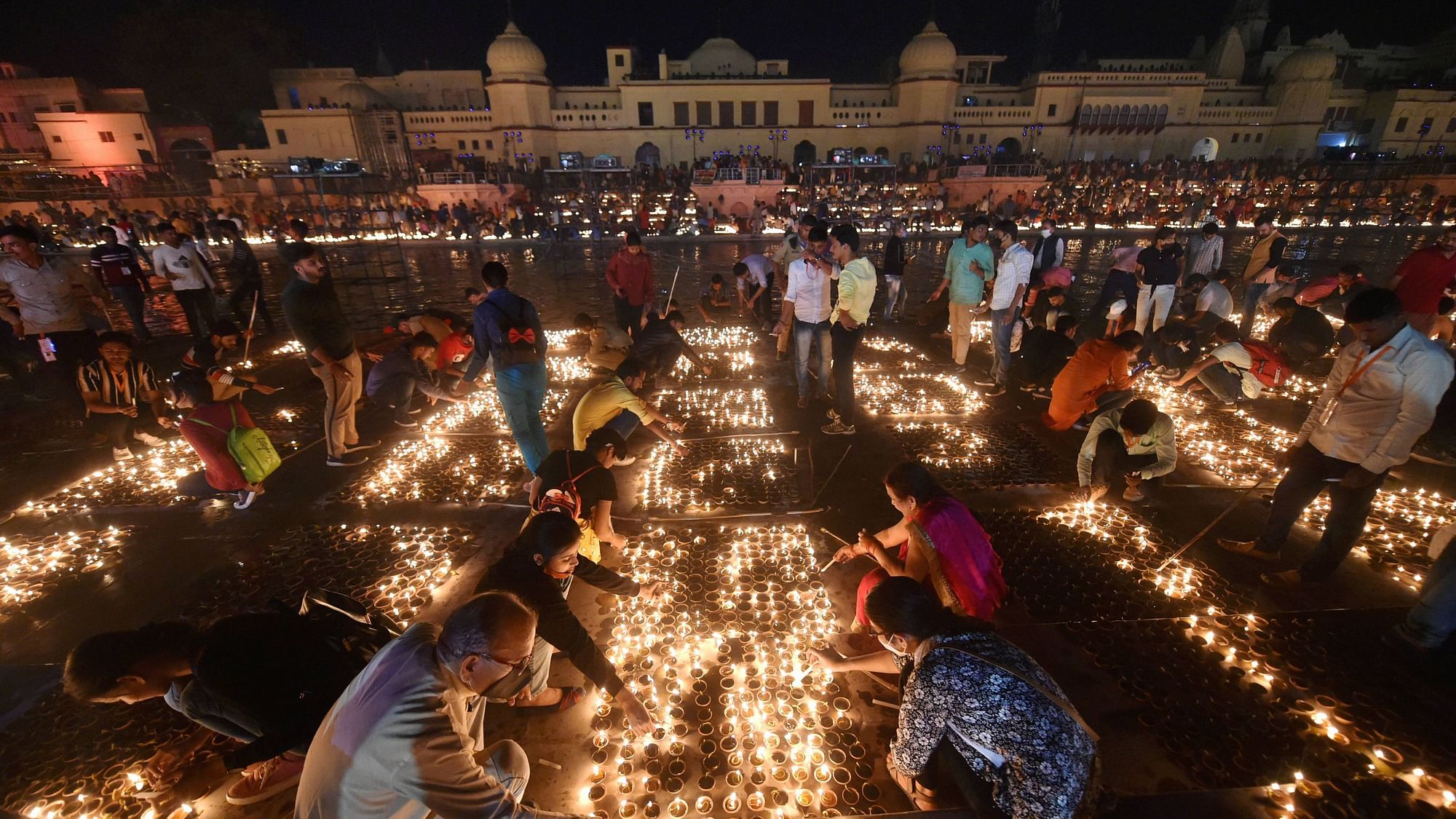 Devotees light earthen lamps on the bank of Saryu River during Deepotsav celebrations in Ayodhya, Friday, 13 November.