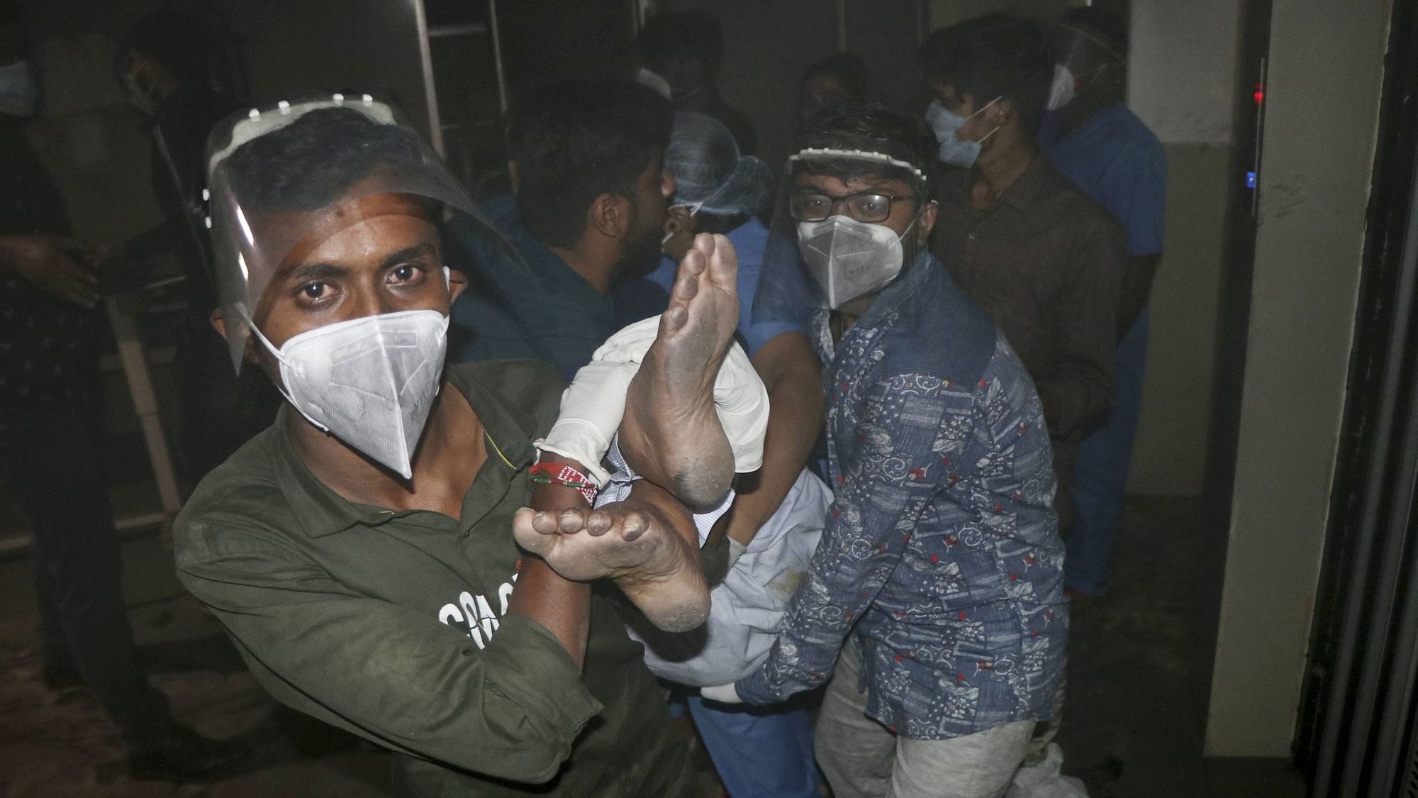  Rescue workers and hospital staff move COVID-19 patients to a safer place after the fire broke out in the ICU of a designated COVID-19 hospital, in Rajkot, Friday, Nov. 27, 2020. Five COVID-19 patients died in the incident.