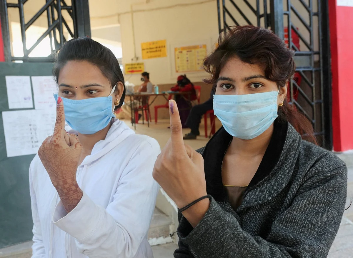 Women show their fingers marked with indelible ink after casting vote during the Madhya Pradesh Assembly bypolls, amid the ongoing coronavirus pandemic, in Raisen district, Tuesday, 3 November.
