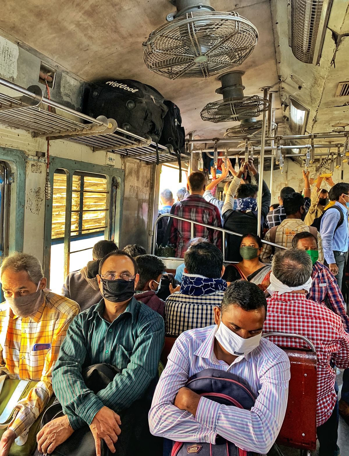 As local train service resumes in Kolkata, passengers neglect COVID norms.