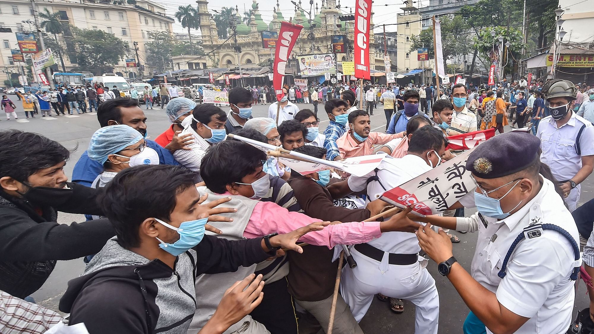 Police personnel detain protestors as they block a road during a protest in support of the nationwide strike by ten central trade unions against various policies of the NDA government, in Kolkata, Thursday, Nov. 26, 2020.