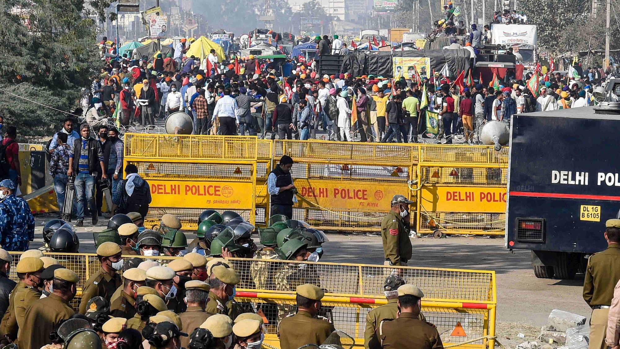 Police stand guard near a barricade as farmers protest at Singhu border during their Delhi Chalo march against the Centres farm reform laws, in New Delhi.