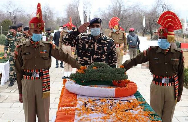 Border Security Force (BSF) officer lays wreath on the coffin of their colleague, who was killed in a ceasefire violation at the Line of Control (LoC) in Kashmir during a wreath laying ceremony in Humhama, on the outskirts of Srinagar, November 15, 2020.