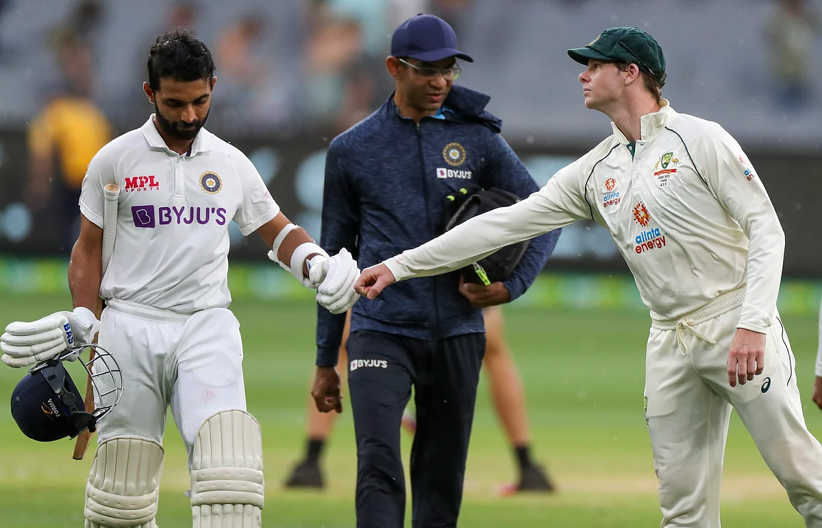 Ajinkya Rahane, left, is congratulated by Australia’s Steve Smith as they leave the field at the close of play on day two of the second test between India and Australia at the Melbourne Cricket Ground.