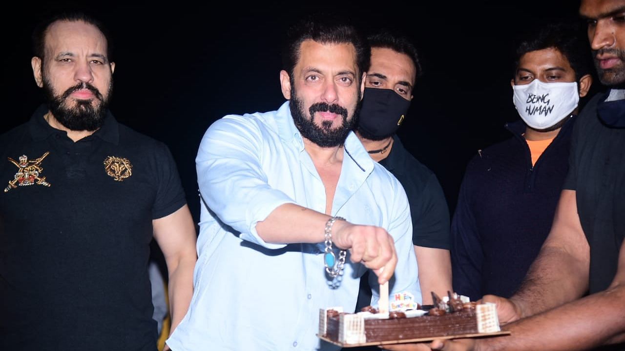 Salman Khan posing for photographers as he cuts his birthday cake outside his farmhouse.