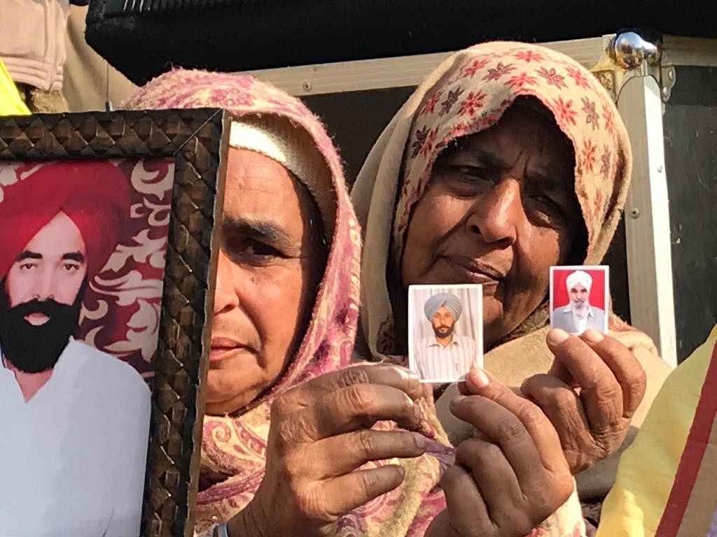 Holding photographs of their kin, the women raised slogans against the new farm laws, at Delhi’s Tikri border.