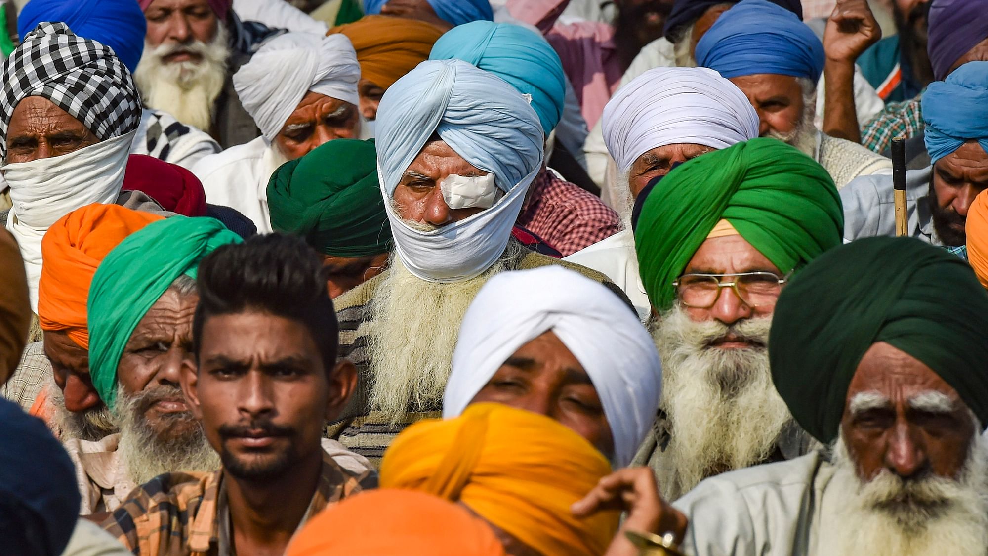  An injured farmer sits among others as they stage a protest at the Singhu border against the Centre’s new farm laws, in New Delhi, on 2 December 2020.