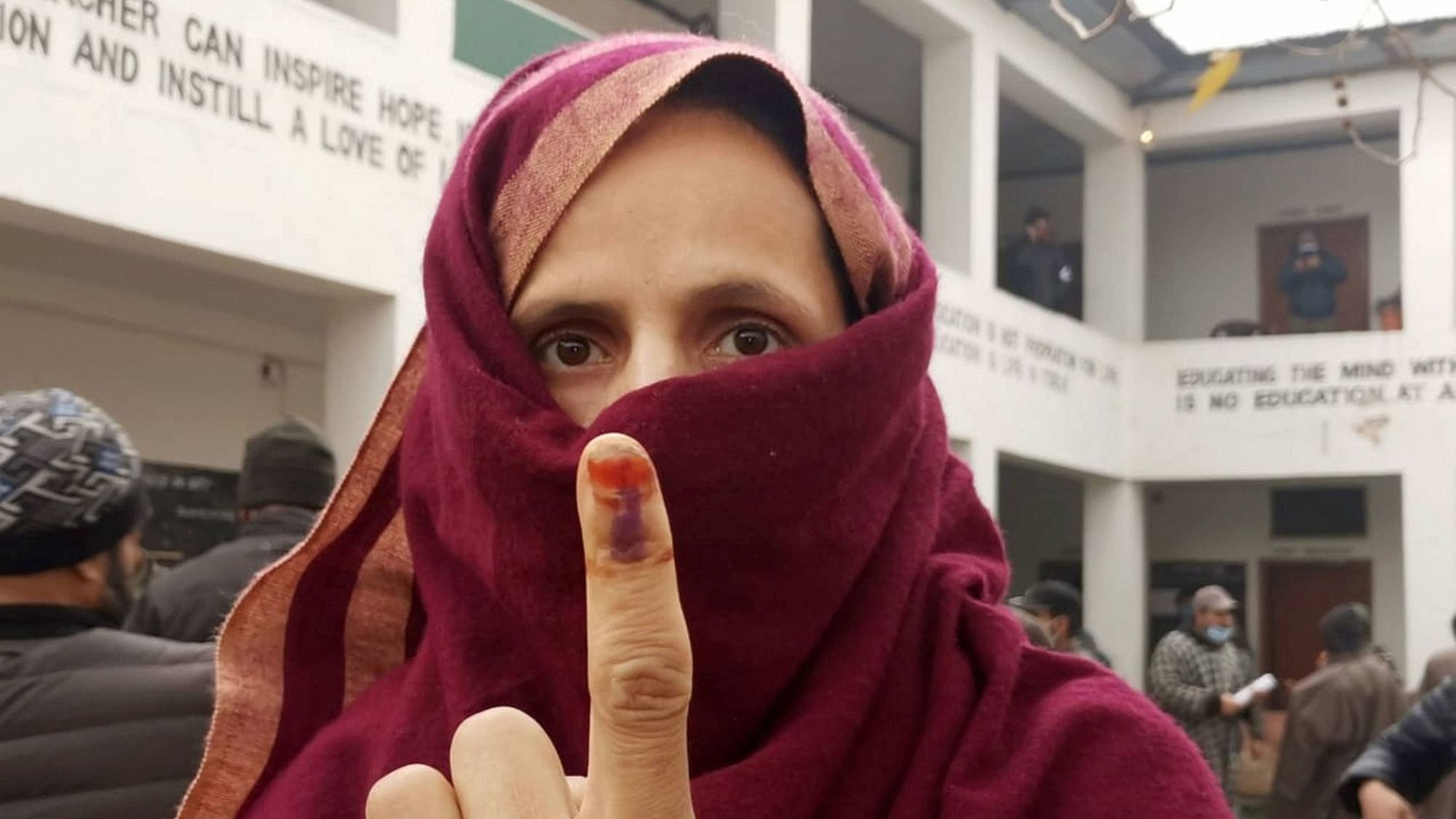 A woman shows her ink-marked finger after casting her vote during the third phase of the DDC elections, at a polling station in Ganderbal area of central Kashmir, on Friday, 4 December 2020.