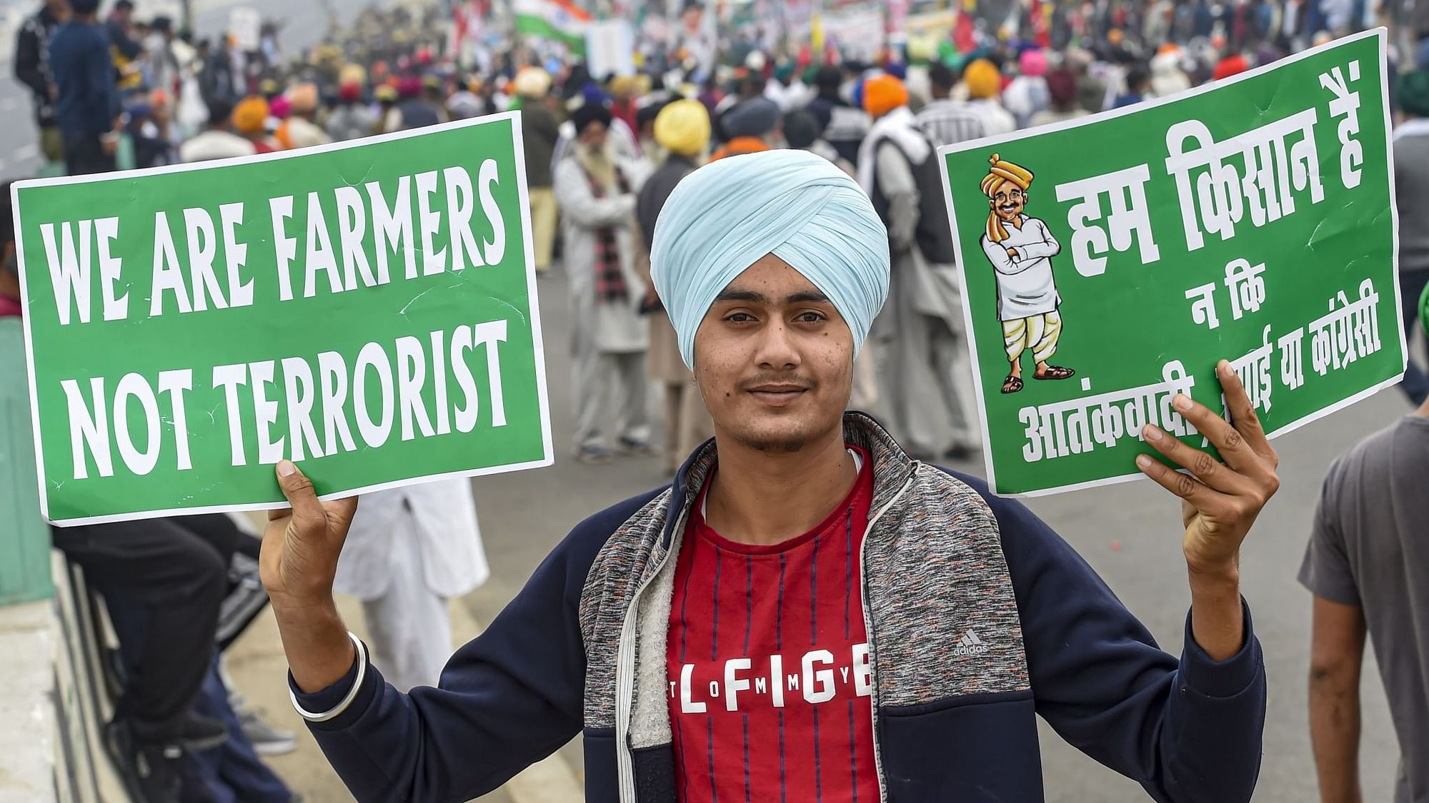 New Delhi: A farmer holds placards during a protest march against Centres agri-laws, at Delhi-Meerut Expressway in New Delhi, Friday, Dec. 11, 2020.
