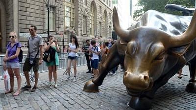People queue beside the bronze bull in the Financial district which has become a Wall Street icon in New York City,  18 July, 2013. (Xinhua/Wang Lei)