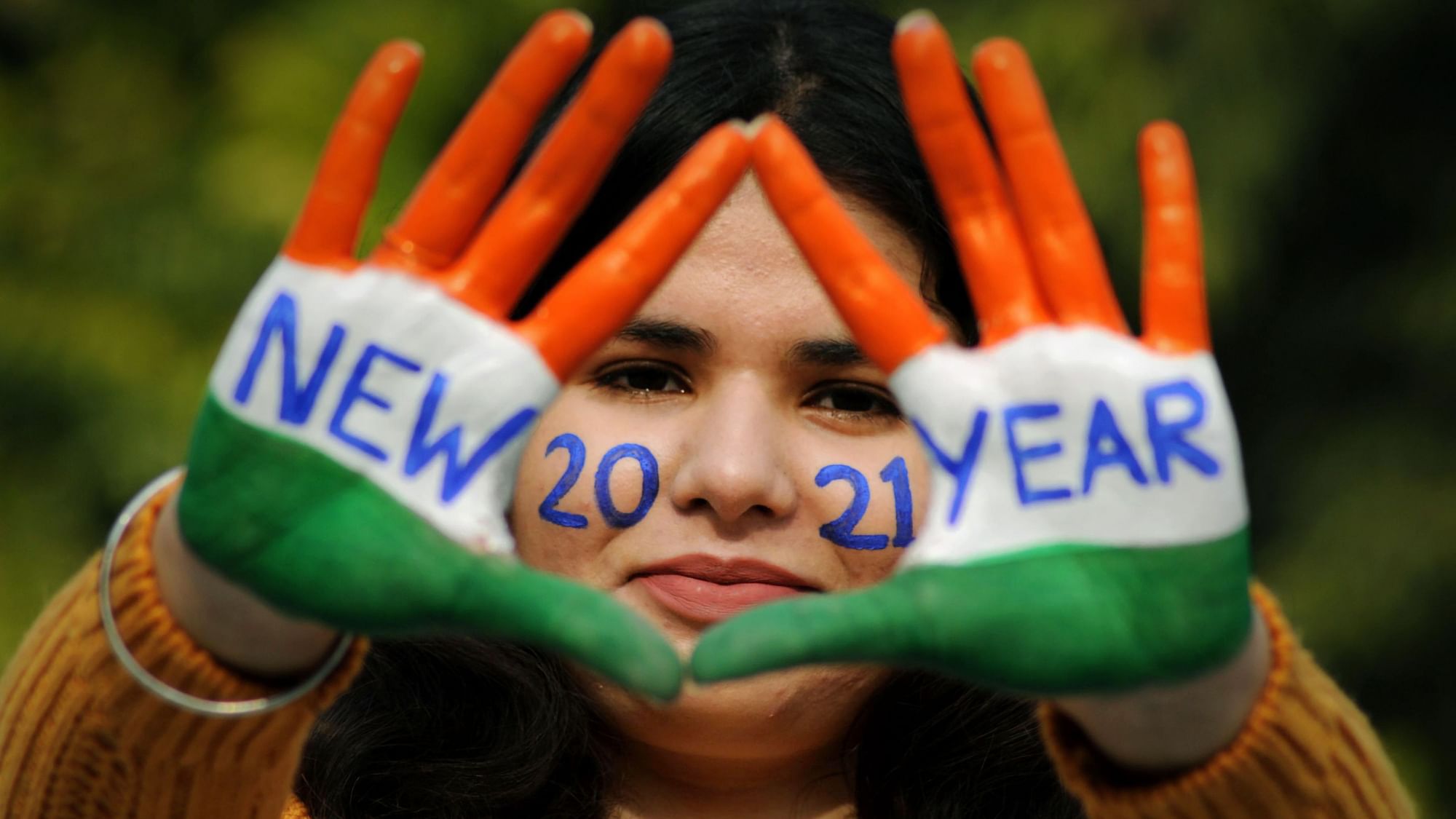  A young woman with painted hands poses for a photograph on the eve of New Year 2021, in Amritsar, Thursday, 31 December.