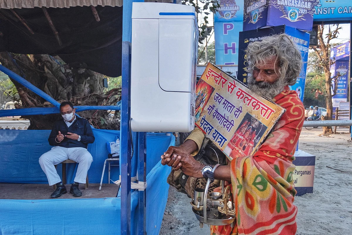 <i>Sadhus and d</i>evotees sanitize their hands at the entrance.