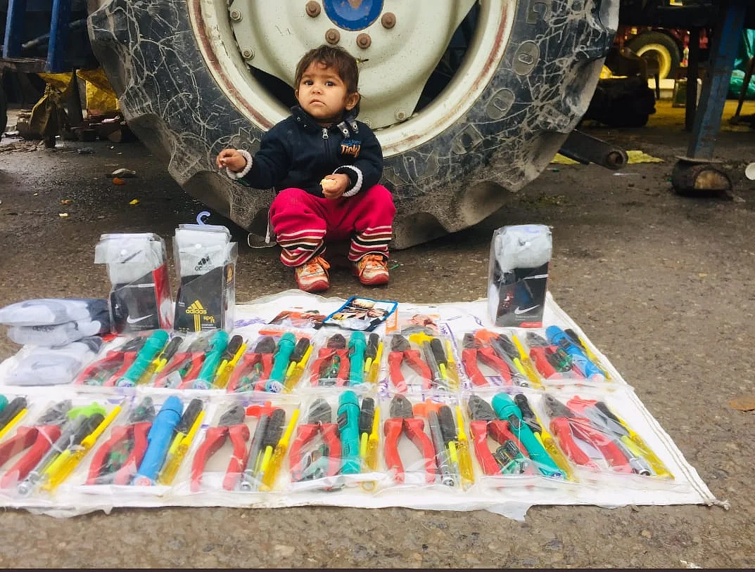 A child sits at the site of a tractor rally.