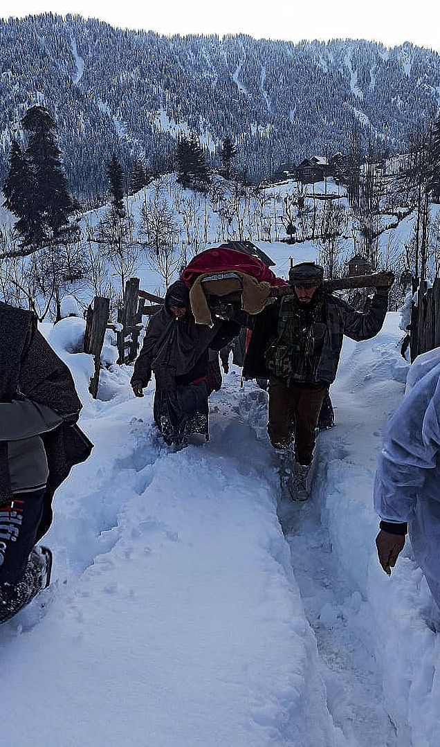 The army personnel helped carry the woman to the main road so she could reach the hospital.