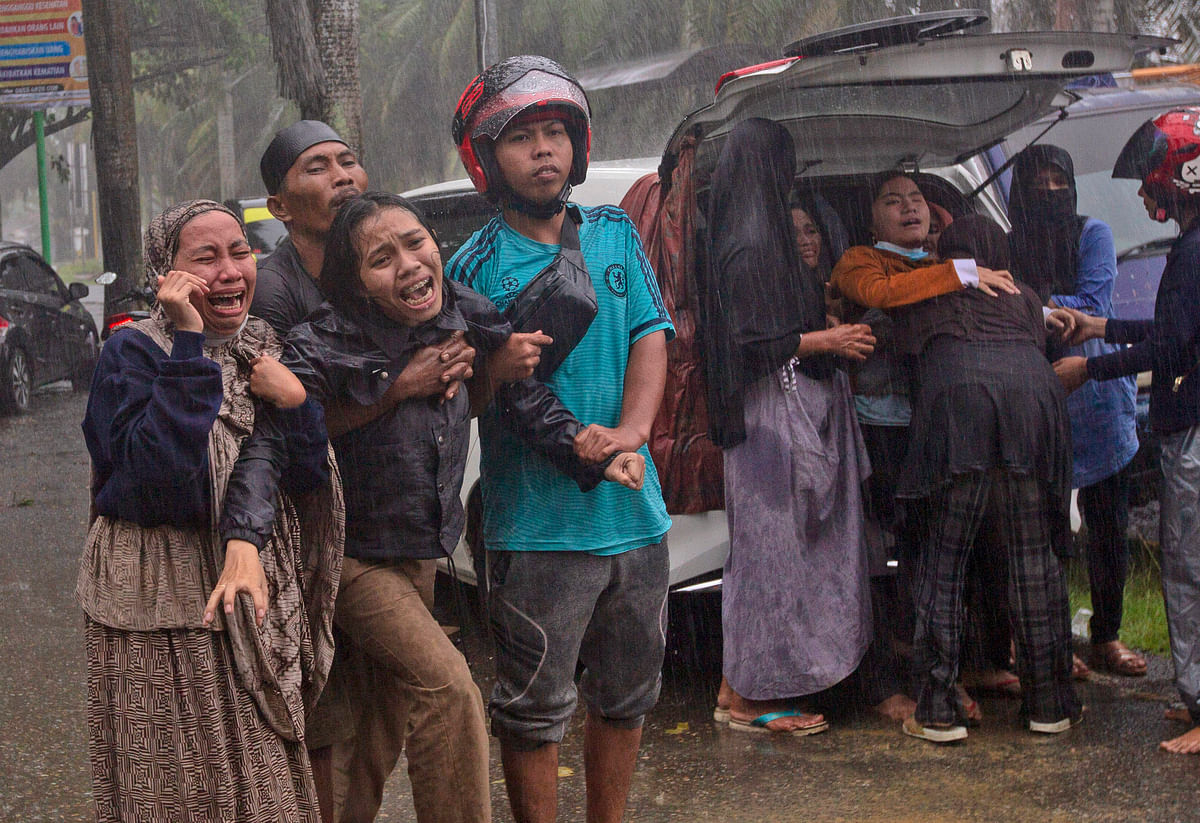People react as the body of a relative is retrieved from the ruin of a building at an area affected by an earthquake in Mamuju, West Sulawesi, Indonesia, Friday, 15 January, 2021. A strong, shallow earthquake shook Indonesias Sulawesi island just after midnight Friday, toppling homes and buildings, triggering landslides and killing a number of people