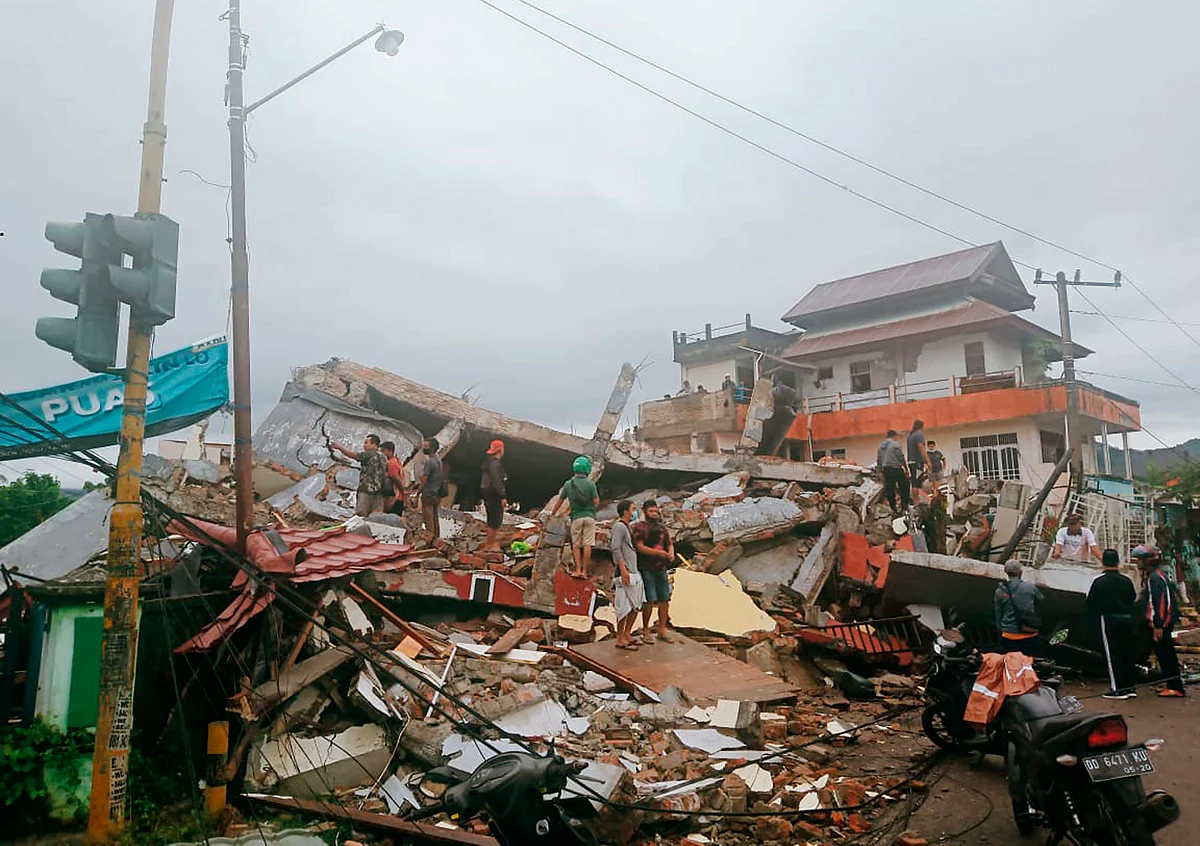 Residents inspect earthquake-damaged buildings in Mamuju, West Sulawesi, Indonesia, Friday, 15 January, 2021. A strong inland and shallow earthquake hit eastern Indonesia early Friday causing people to panic in parts of the countrys Sulawesi island and run to higher ground.