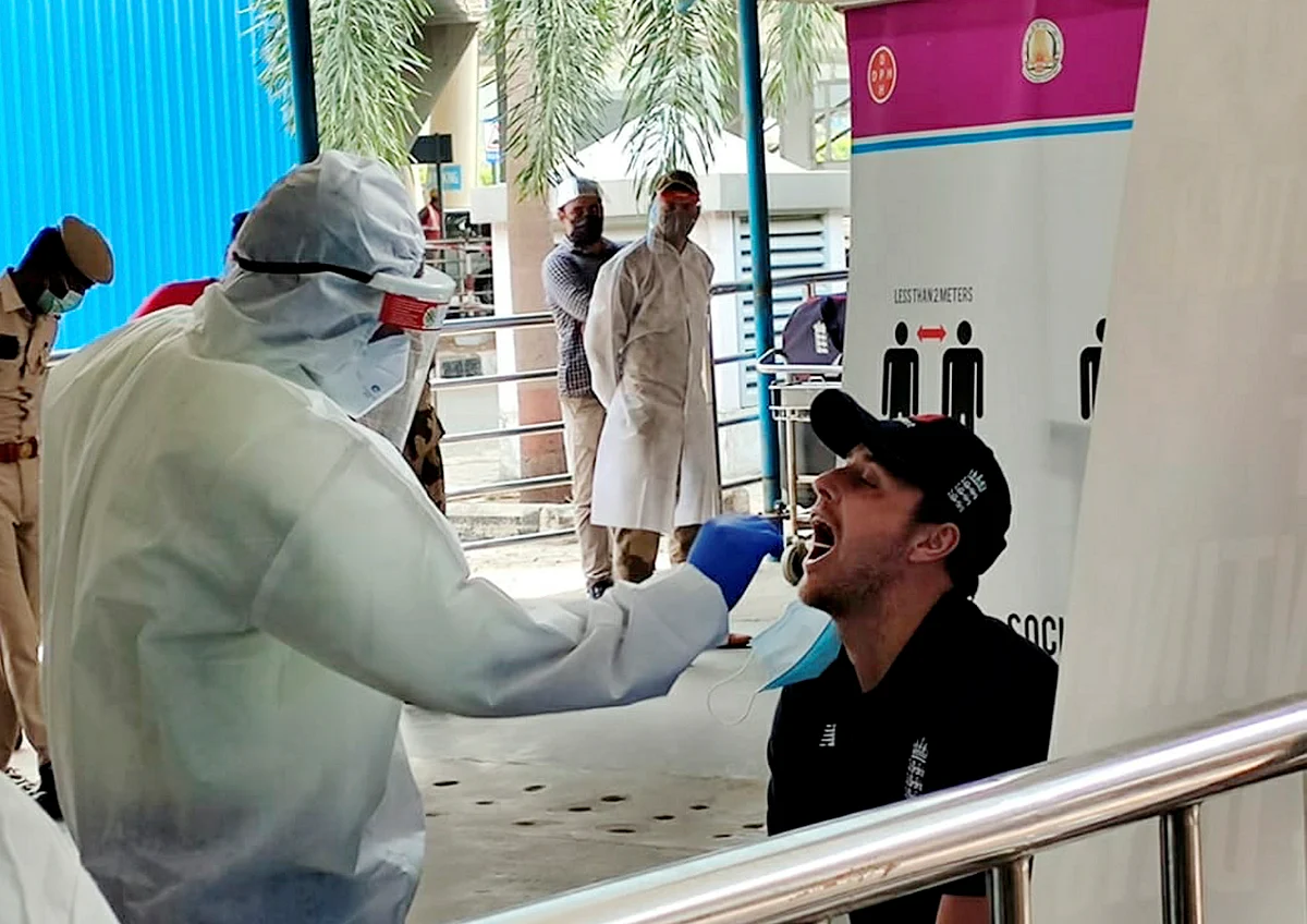 A player of England cricket team gives his swab sample to a medic for COVID-19 test as he arrives at the airport ahead of the test series against India, in Chennai, Wednesday, 27 January 2021.