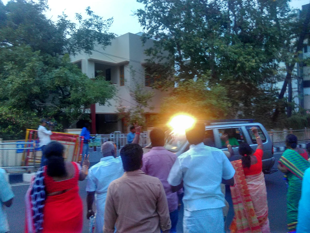 This photo is from February 2016 of Jayalalithaa leaving her residence to people waving to her. The bright light seen in the photo is of the light that is strategically placed inside the car so that <i>Amma’s </i>face looks lit up.