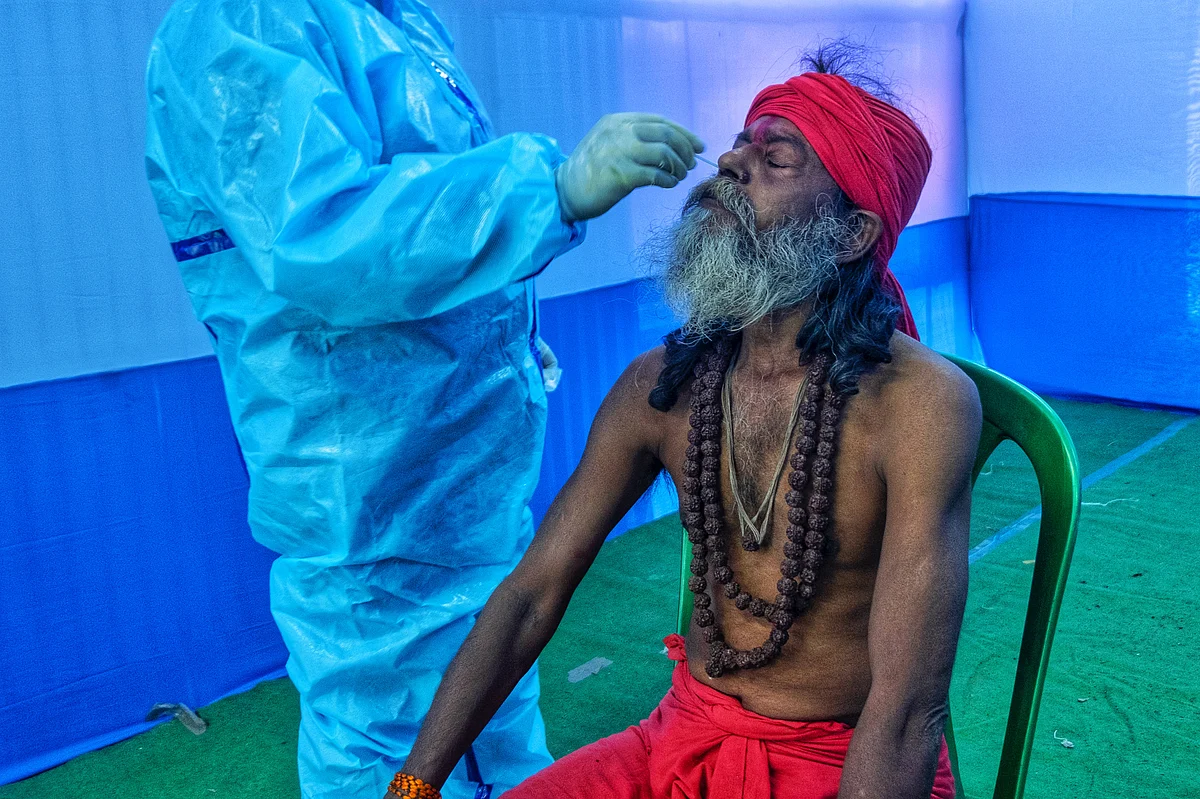 A healthcare worker collecting the swab sample of a devotee.