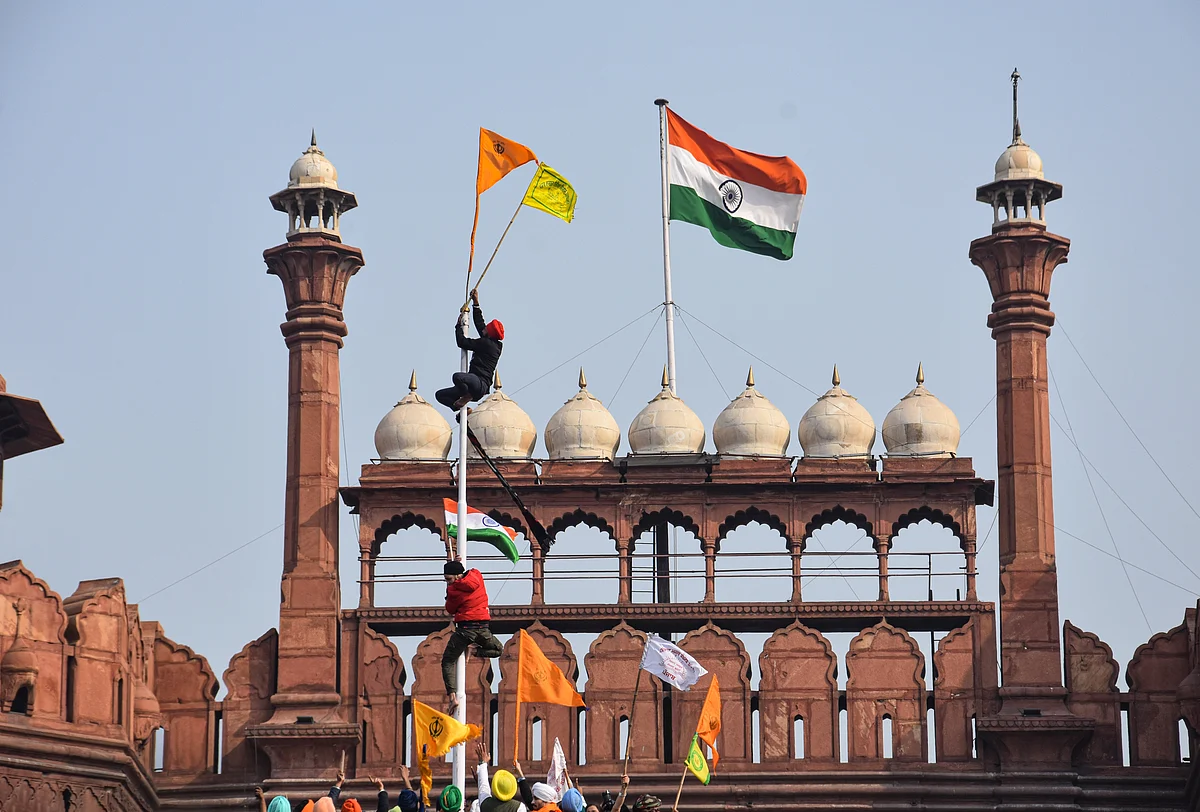 Farmers hoist flags at the Red Fort during the Kisan Gantantra Parade amid the 72nd Republic Day celebrations, in New Delhi, Tuesday, 26 January 2021.
