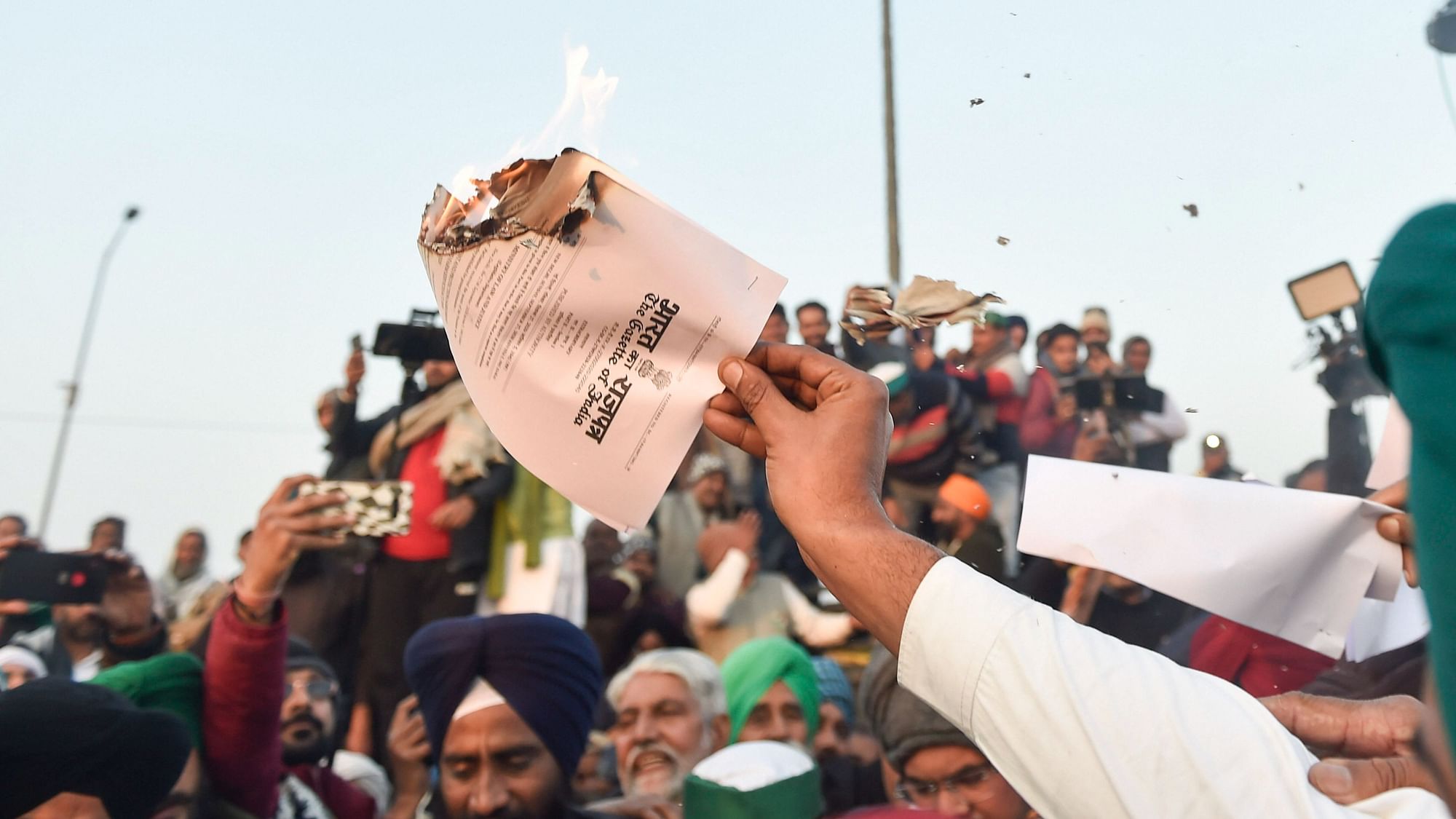 Farmers burn copies of the farm bill during Lohri festival amid the ongoing protest at Ghazipur border in New Delhi, Wednesday,13 January 2021.