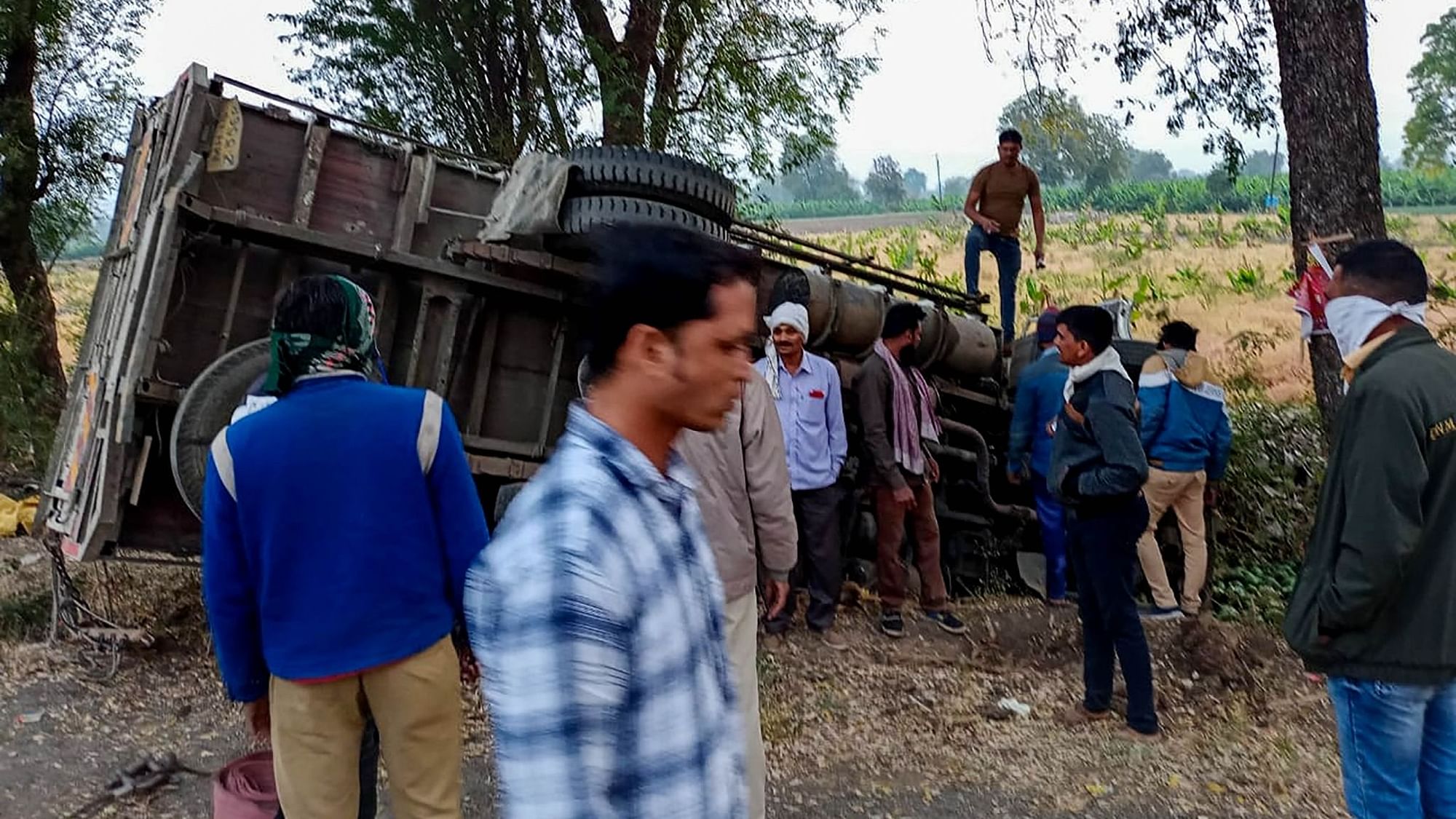 People gather near the mangled remains of a truck after it overturned near Kingaon village, killing at least 16 labourers, in Jalgaon district of Maharashtra, Monday, 15 February.