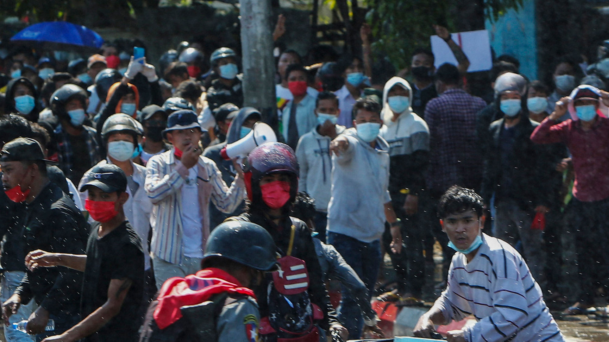 File photo of protesters running after police fired warning shots and water cannon to disperse them during a protest in Mandalay, Myanmar, in February.&nbsp;