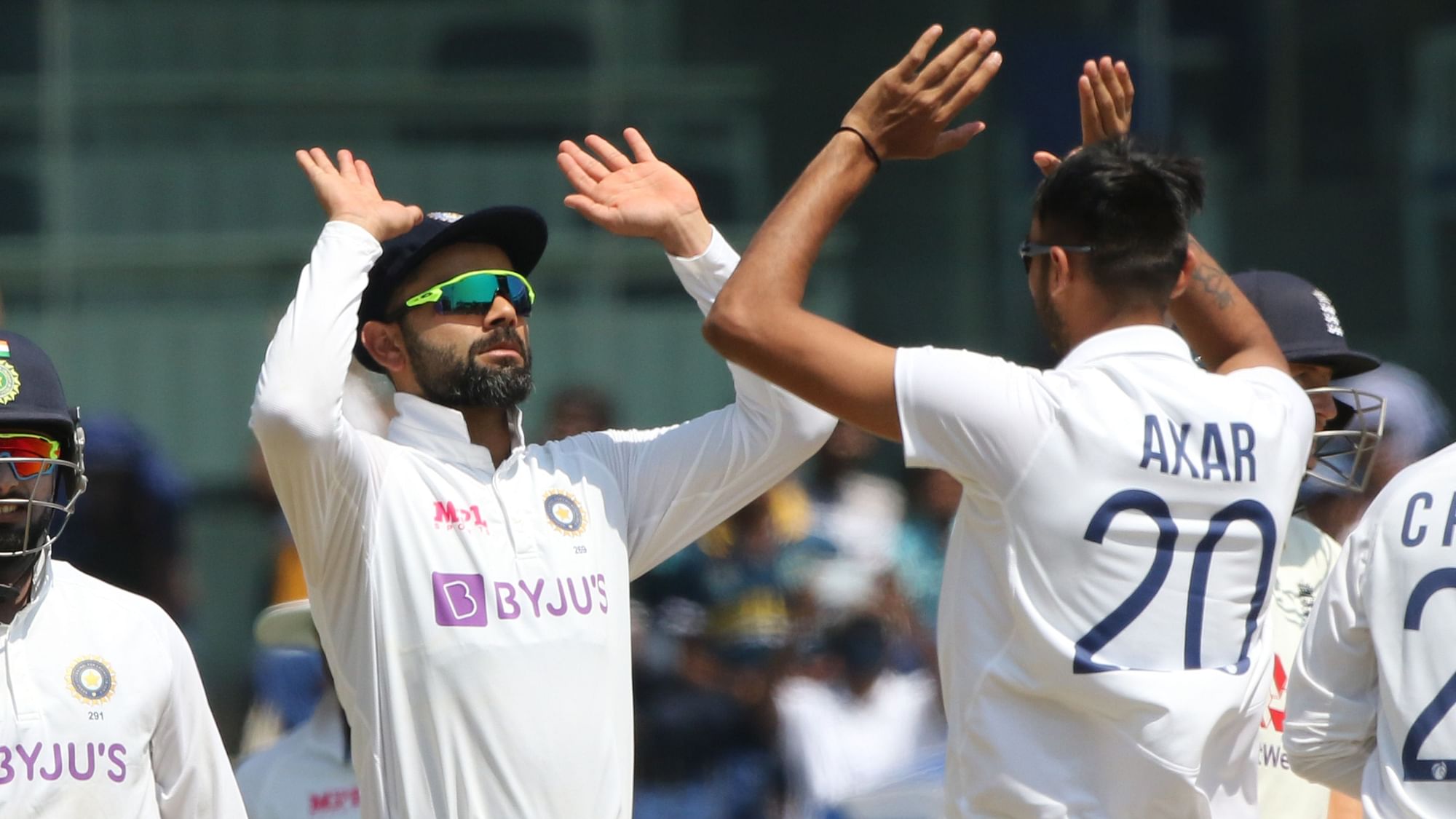 Axar Patel and Virat Kohli celebrate Joe Root’s wicket.&nbsp;