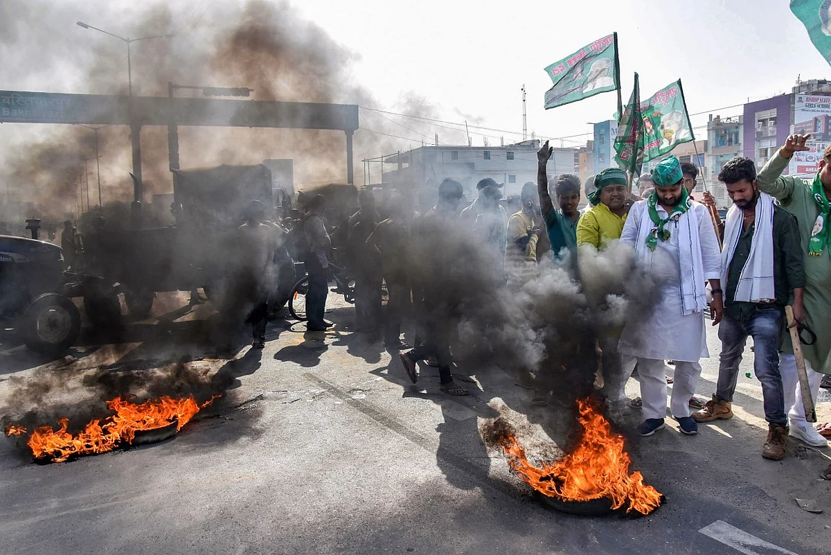 Activists burn tyres as they block a road during a nationwide strike, called by farmers unions against the three farm laws, in Patna, Friday, March 26, 2021.
