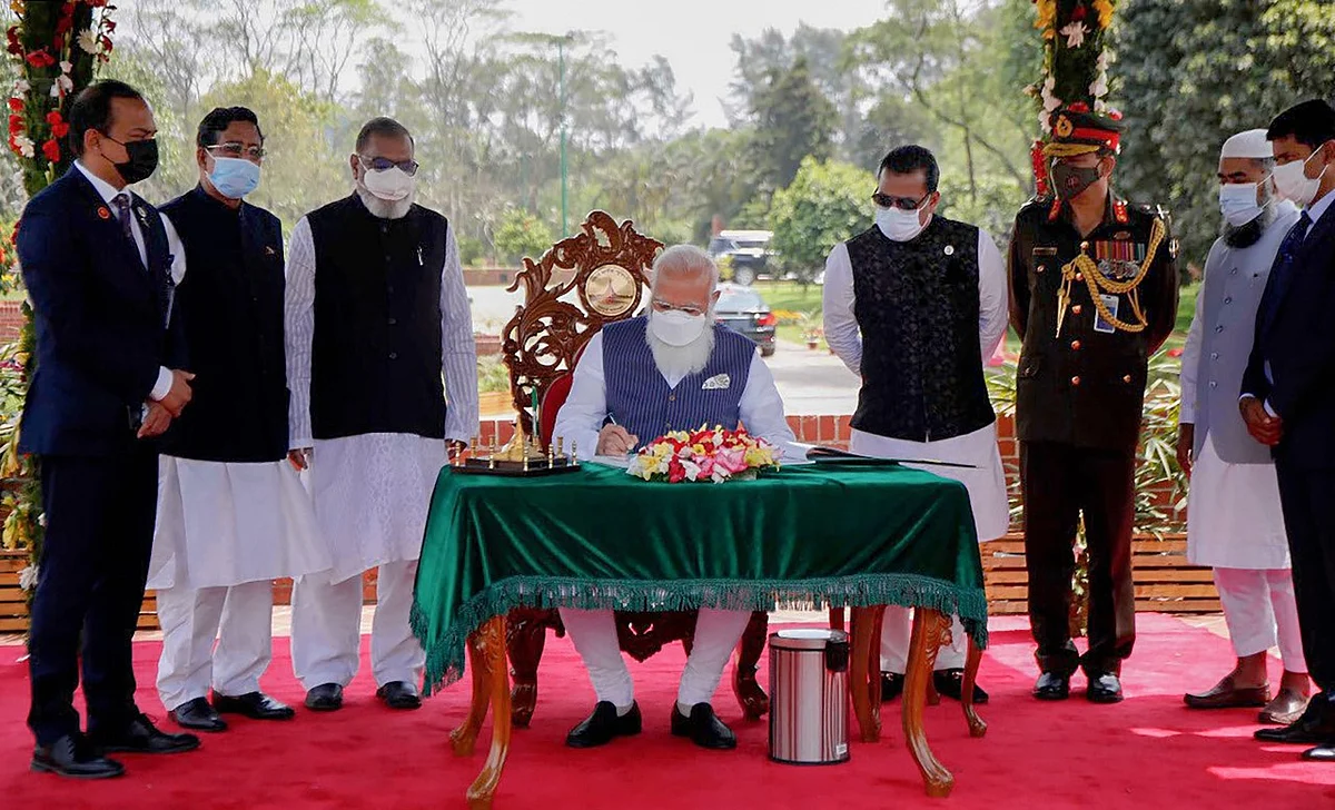 Prime Minister Narendra Modi signs the visitor book at the National Martyr’s Memorial in Savar, on the occasion of 50th Independence Day of Bangladesh, in Dhaka, Friday, March 26, 2021