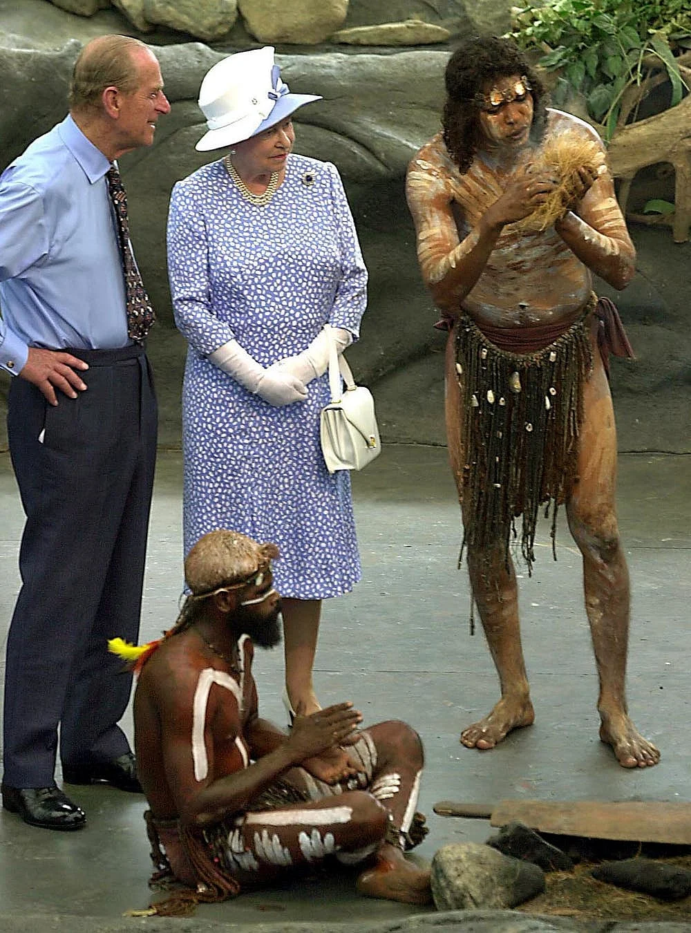 Queen Elizabeth II and Prince Philip watch as Warren Clements of the Tjapakai Aboriginal Dance Group makes fire by rubbing sticks in Cairns in March 2002. 