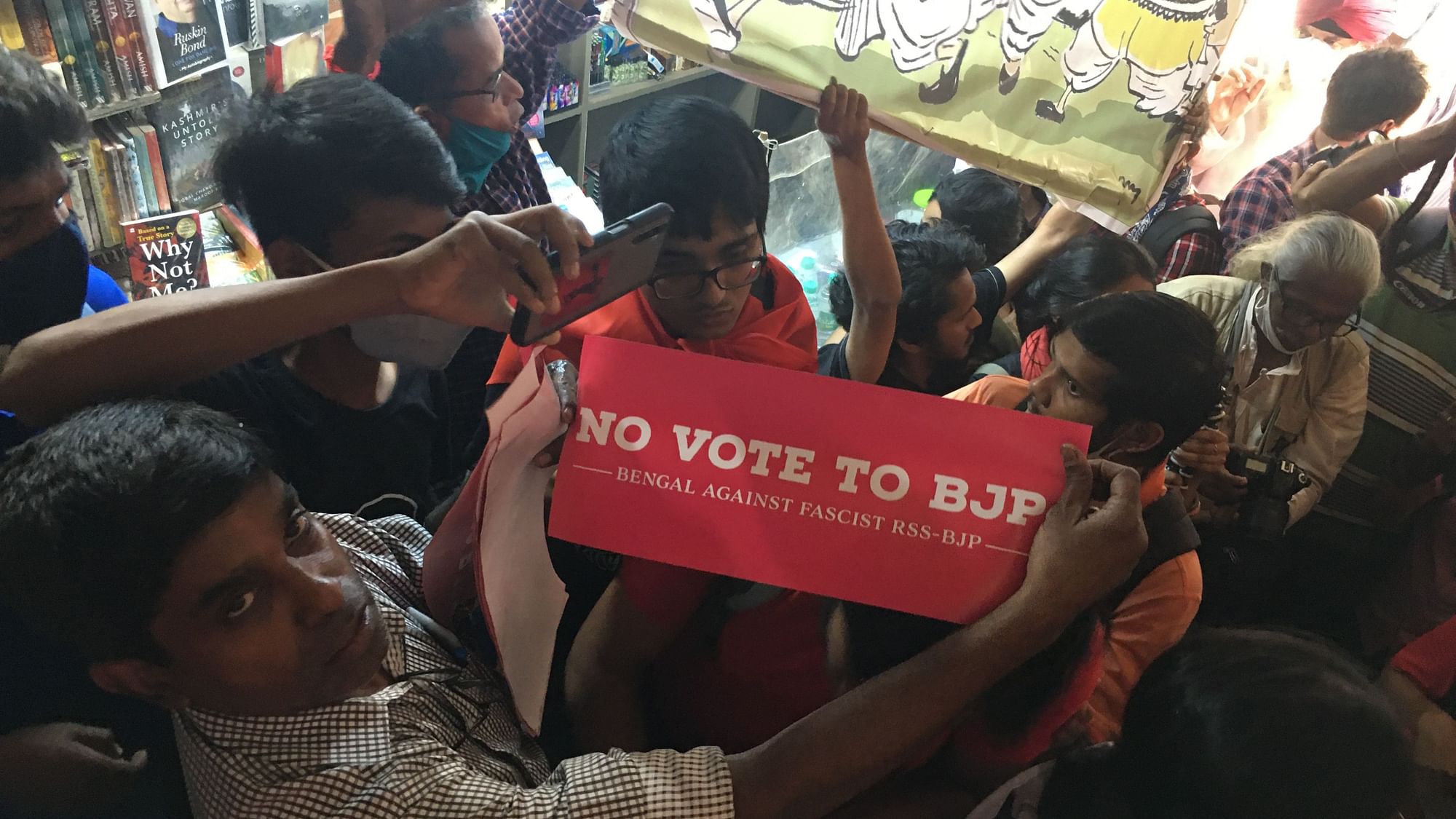 Protestors hold up a ‘No Vote to BJP’ poster at Coffee House