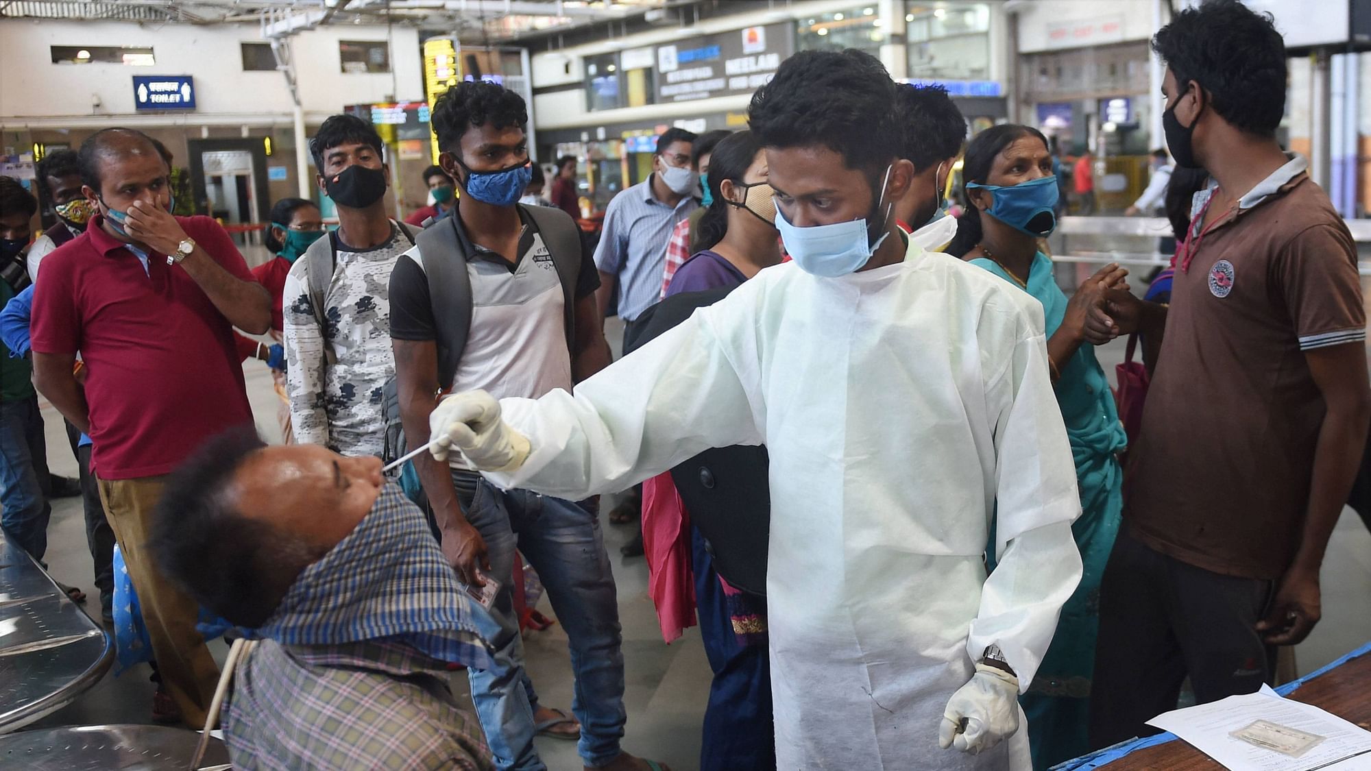 A health worker collects nasal sample from a passenger for COVID-19 test, at the Chhatrapati Shivaji Maharaj terminus in Mumbai.