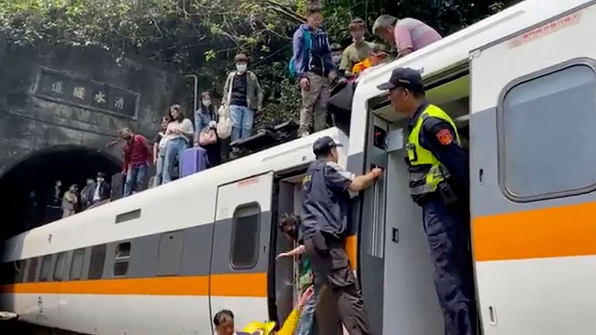 In this image made from a video released by hsnews.com.tw, passengers are being helped to climb out of the derailed train in Hualien County in eastern Taiwan on Friday, April 2, 2021. The train partially derailed along Taiwan’s east coast on Friday, injuring an unknown number of passengers and causing several fatalities. 