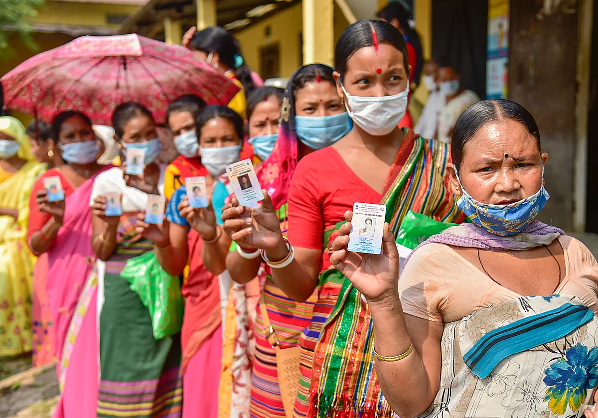 Kamrup: Hajong tribal women show their voter identity cards as they wait in the queue to cast their votes at a polling Station for Assembly polls, at Boko in Kamrup district, Tuesday, April 6, 2021.