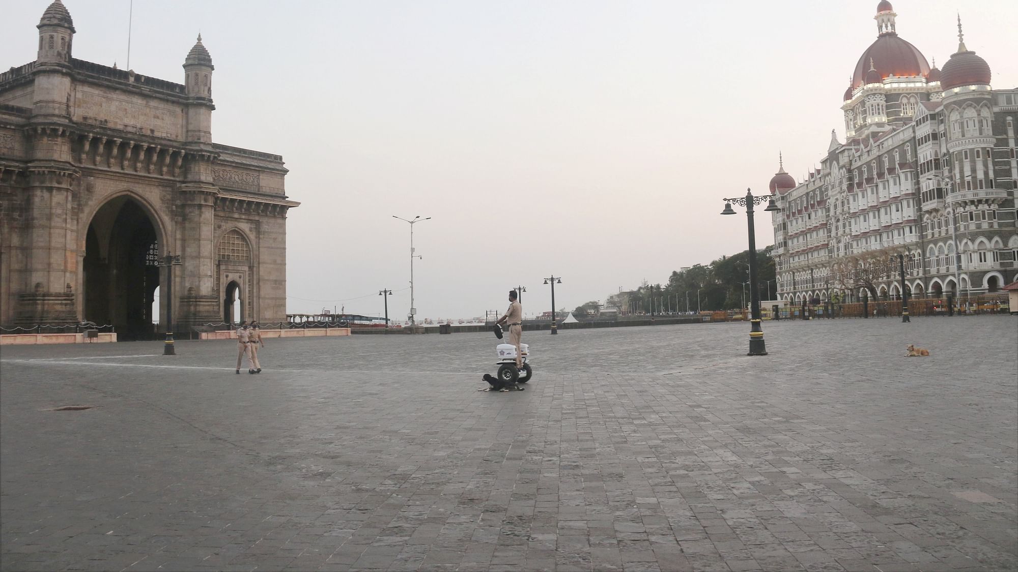 Police officers patrol the deserted Gateway of India, after authorities closed all public spaces due to surge in COVID-19 cases, in Mumbai on Monday, 5 April.