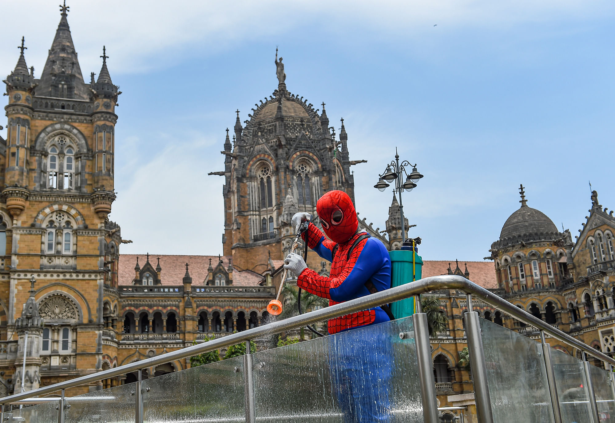 Social worker Ashok Kurmi, dressed as fictional superhero Spider Man, sanitises the area around Chhatrapati Shivaji Maharaj Terminus, during a COVID-induced lockdown to curb the spread of the coronavirus in Mumbai on Wednesday, 21 April.&nbsp;