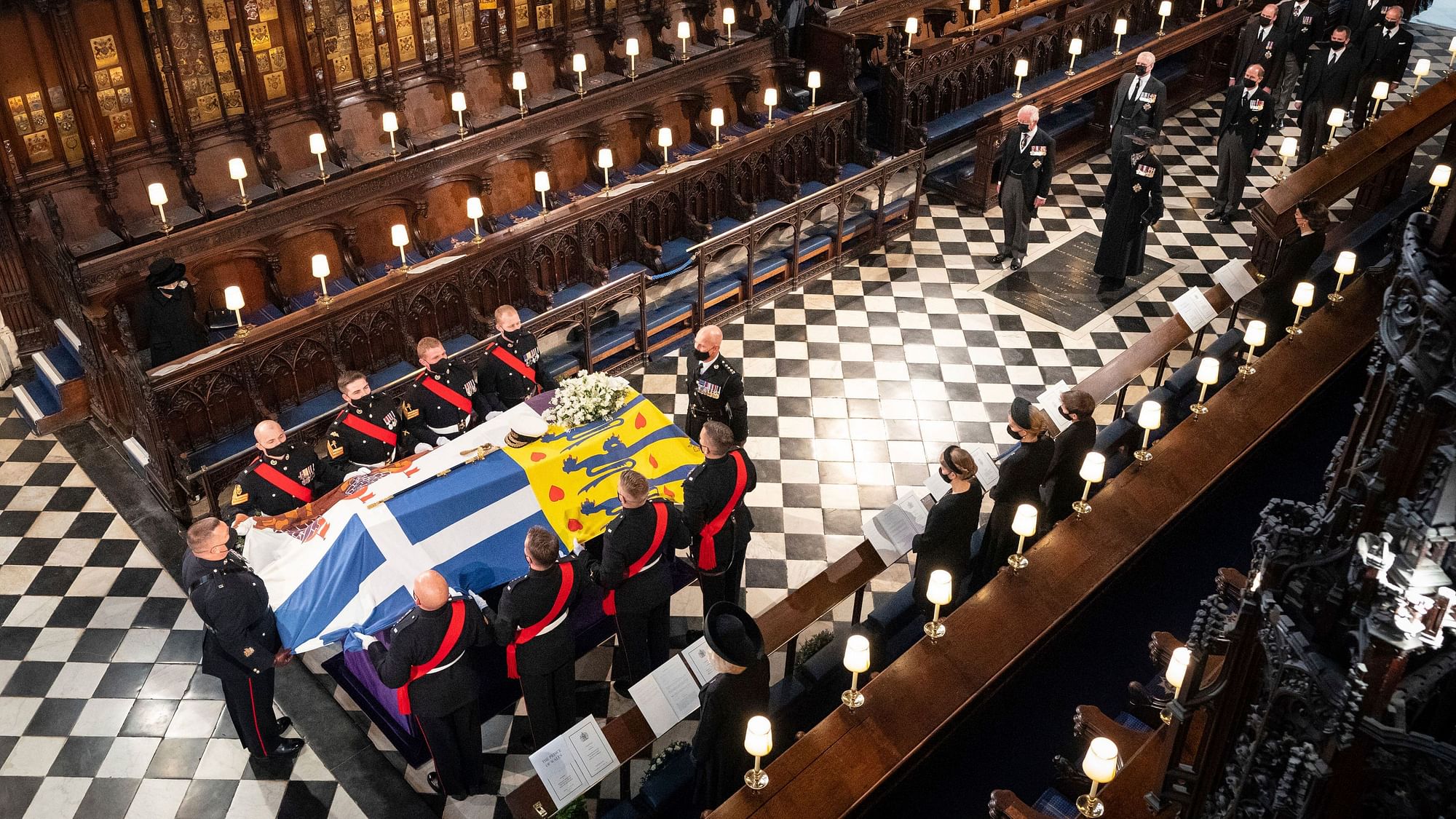 Queen Elizabeth watches as pallbearers carry the coffin of the Duke of Edinburgh during his funeral, at St Georges Chapel in Windsor Castle, Windsor, England.
