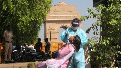 Health worker wearing PPE kit collects swab sample for COVID-19 testing at India Gate in New Delhi.