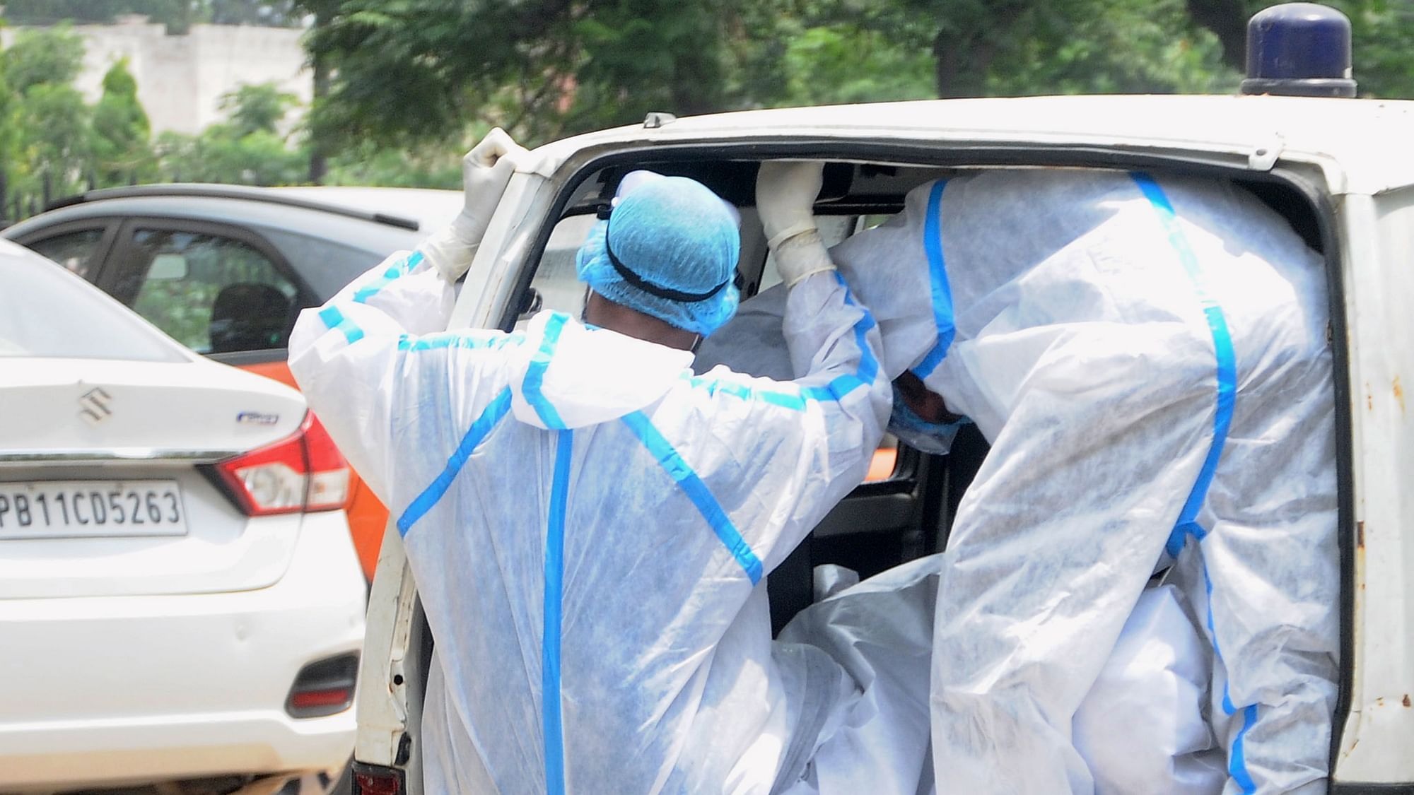 Health workers wearing PPE kits carry the body of a COVID-19 victim from a mortuary for cremation. Image used for representational purposes.